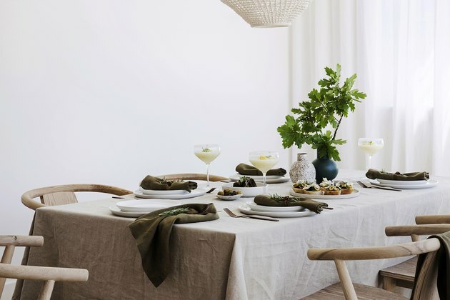 mesa de jantar com roupa de cama neutra e talheres
