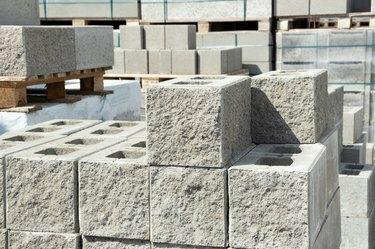 Sklad cementnega betona Gradbena opeka iz žerjavih blokov na paleti v trgovini s strojno opremo s stranjo teksture okrasnega kamna