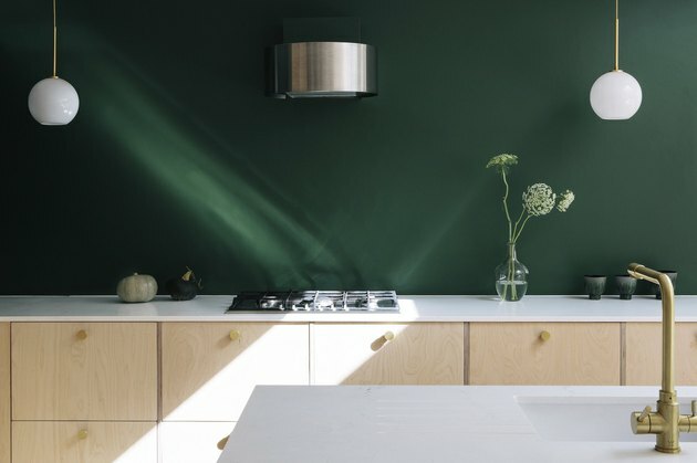فكرة المطبخ الحديثة مع الخشب الرقائقي والجدار الأخضر الزمرد