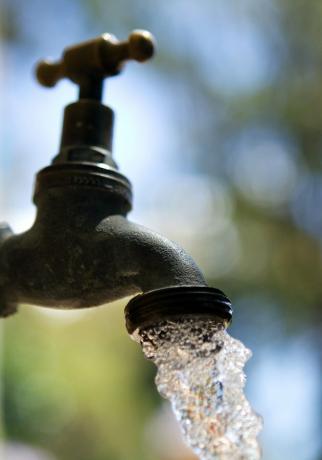 L'eau coule d'un robinet de jardin.