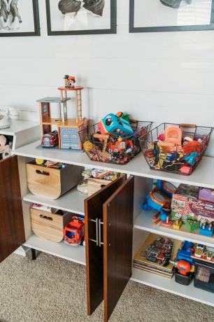 Idéias de organização de brinquedoteca com brinquedos em cestas armazenadas em buffet