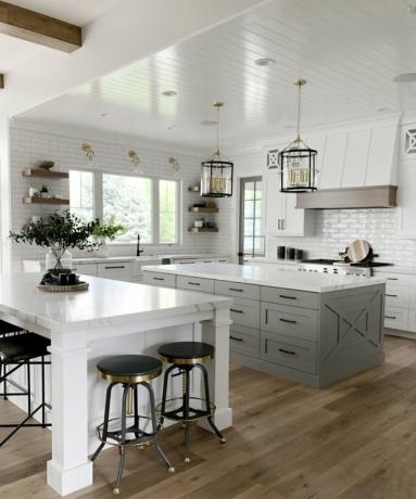grande cucina bianca con isola grigia e isola di marmo