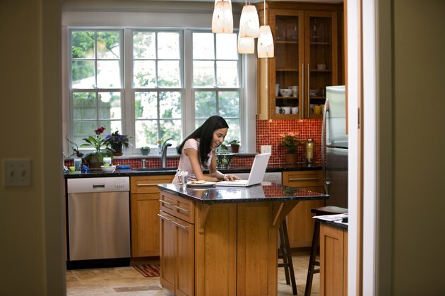 Donna in cucina sul computer portatile