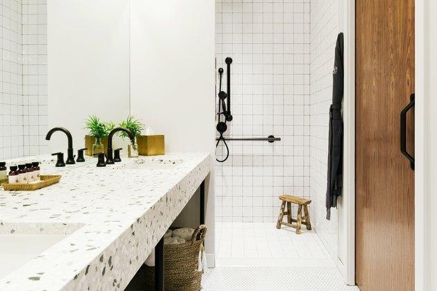 chuveiro minimalista branco com azulejos quadrados em grade e acessórios pretos