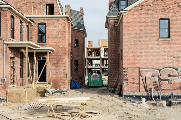 onvoltooide bouwproject op rode bakstenen huis omgeven door vuil en hout