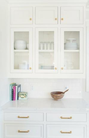 witte keukenkasten met houten kom en boeken op aanrecht