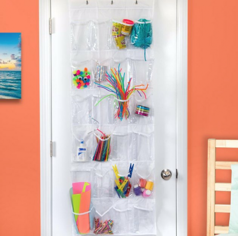 Sobre o armazenamento da porta no quarto com plástico sobre o armazenamento da porta, paredes laranja, brinquedos.