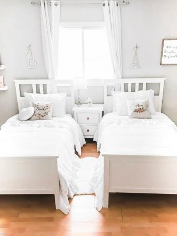 Minimalistische kinderslaapkamer met witte bedden en kussens