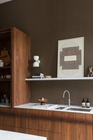 кафяви кухненски стени с дървени шкафове и тънък плот от мрамор