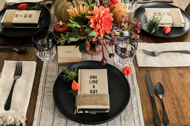 herfstfeest idee met de gunsten van het dagboekfeest op zwarte platen en bloemen, pompoendecor