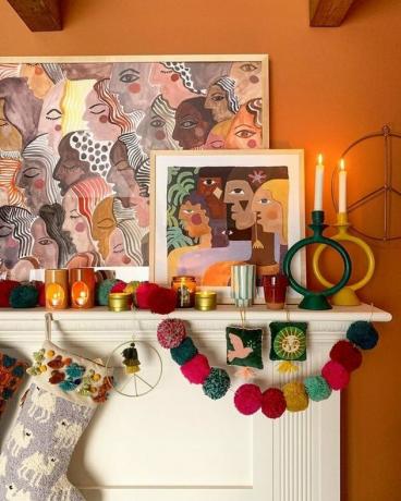 Idéia de decoração de tema de Natal boho com meias e guirlanda pendurada na lareira