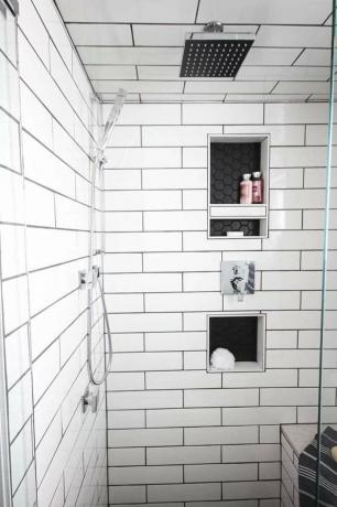 Sistema de chuveiro cromado polido em um moderno chuveiro de azulejo subterrâneo