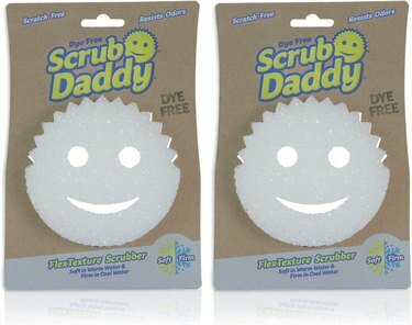 Kaksi pakkausta valkoisia Scrub Daddy hymiösieniä.