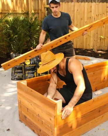 muškarci grade drvene vrtne krevete