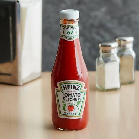 Heinz 14 oz. Frasco de vidro de ketchup na bancada com sal e pimenta