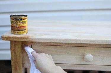 Applicare la macchia di legno sul tavolo di legno con un panno bianco