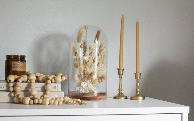 DIY herfstdecor-idee met gedroogde bloemen in de glazen kap