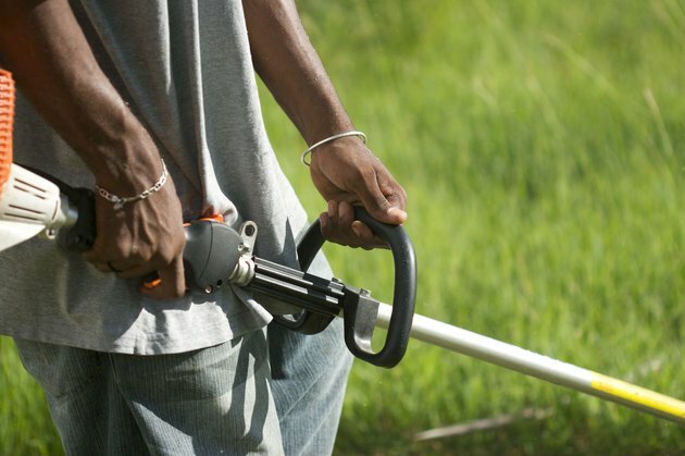 Trädgårdsmästare som klipper gräsmatta i Karibien