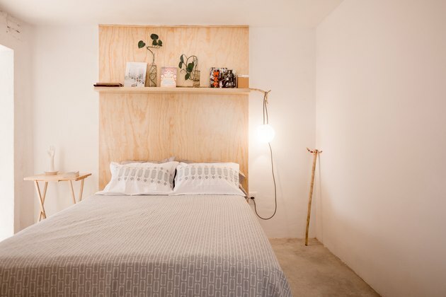 Dormitorio con cabecero de madera de pino.
