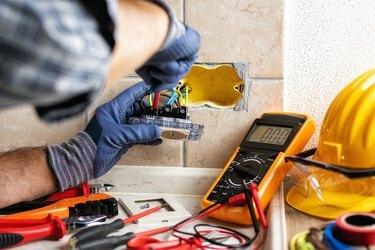 Elektriker på jobb med sikkerhetsutstyr på et elektrisk system i boliger. Elektrisitet.