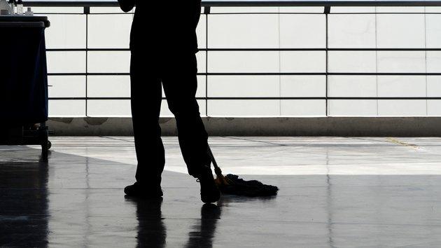 Imagen de silueta de personas de servicio de limpieza barriendo el piso con un trapeador