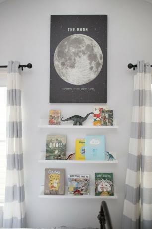 Organização da sala infantil com estantes flutuantes e pôster lunar