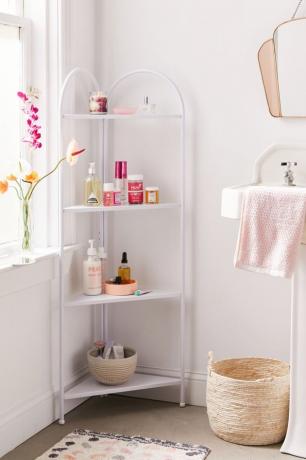 Kúpeľňa Shabby Chic v rohovej kúpeľňovej poličke s pleťovými vodami, košíkom, kvetinami, uterákom, umývadlom, zrkadlom.