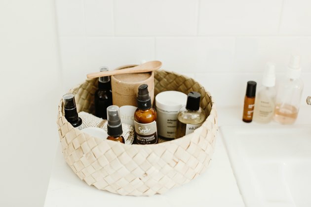 Ideias para organizadores de maquiagem com cesta de produtos de beleza no balcão branco do banheiro