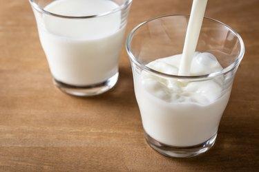 Versare il latte in un bicchiere