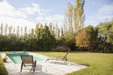 Transats au bord de la piscine dans le jardin