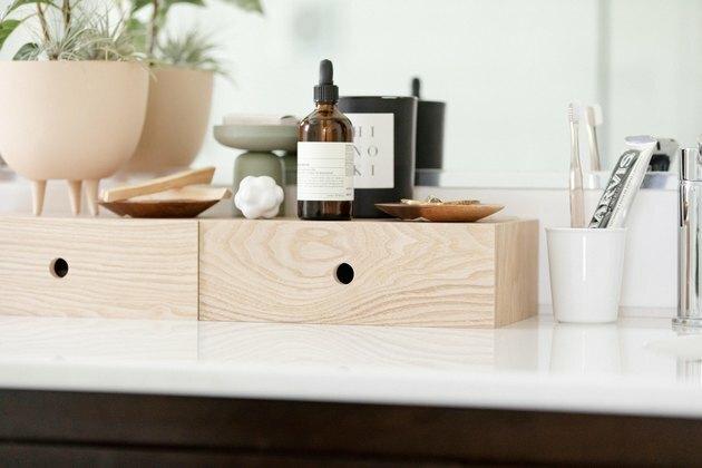 idea di arredamento bagno con scatole di legno sul piano di lavoro per gli elementi essenziali