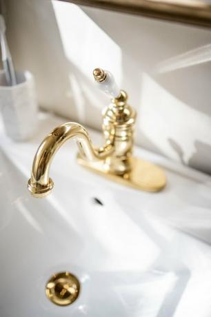 Torneira de latão de inspiração vitoriana na pia do banheiro