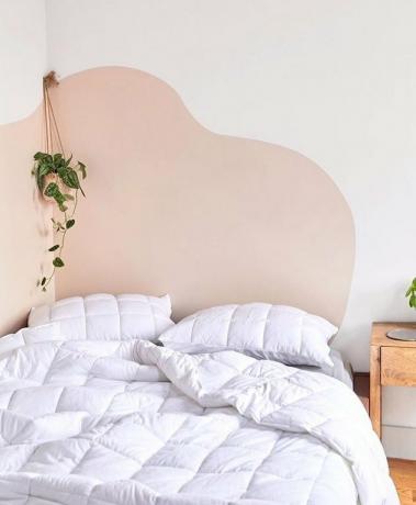 quarto com roupa de cama branca e parede ondulada