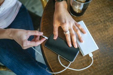 Close-up, dēļ, Woman's, hands, iespraužams, mobilais, telefons, norāda mērķi, power bank