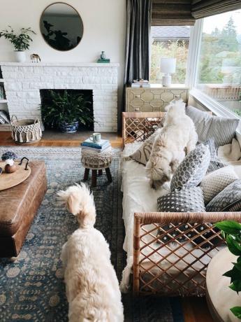 Een boho-chique woonkamer met een ronde spiegel boven de open haard