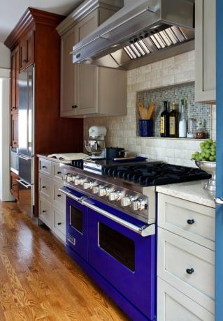 المطبخ الترافرتين في المطبخ مع موقد أزرق وخزائن متعددة الألوان