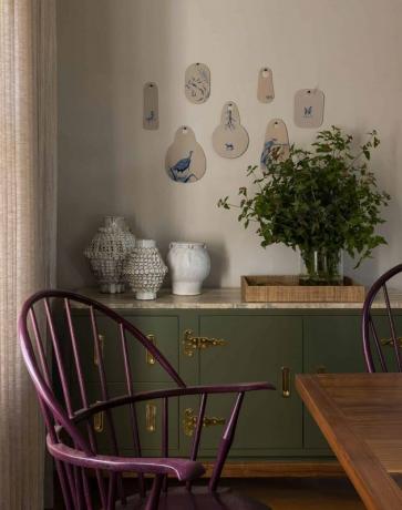 Taupekleur in eetkamer met paarse stoelen en groen buffet