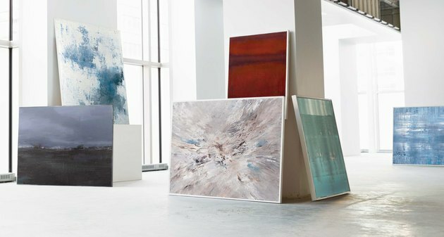 Witte galerieruimte met grote abstracte schilderijen tegen muren