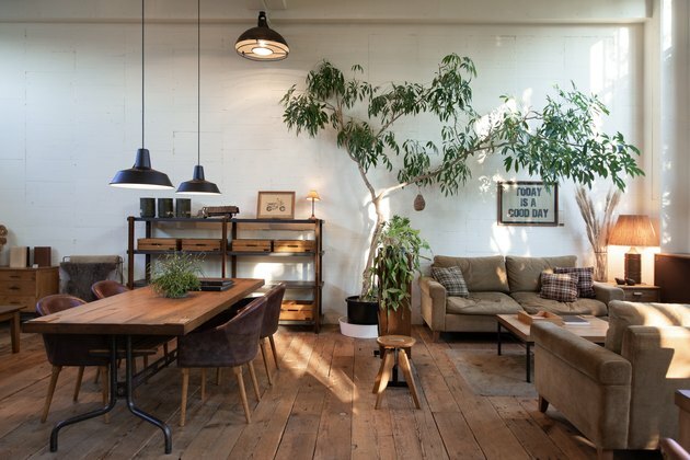 industriële boerderij houten tafel met een dik rustiek blad en metalen poten omgeven door donkerbruine stoelen