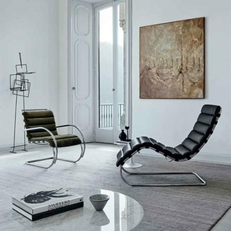 Quarto estilo Bauhaus com cadeiras modernas e escultura contemporânea