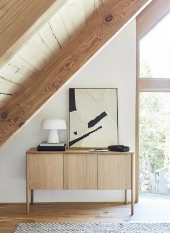 Escritório em casa pintada de cor champanhe com vigas de madeira e console de madeira