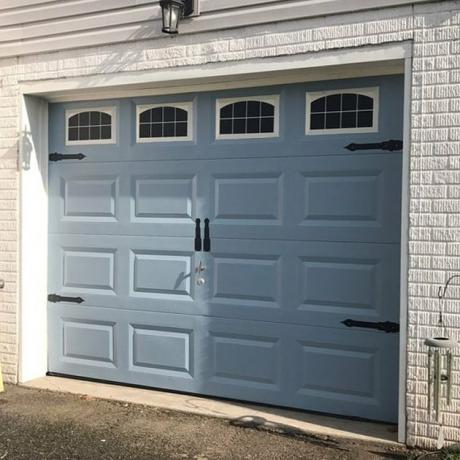 porta azul da garagem com adesivos e ferragens nas janelas
