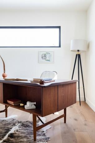 Een houten bureau op een houten vloer met een bonttapijt en een zwart-witte vloerlamp met Home Office Desk Ideas