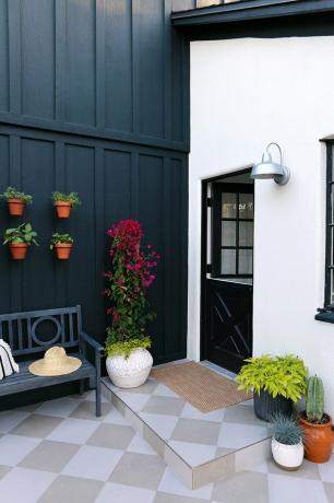porta traseira exterior holandesa preta na casa branca com tapume preto