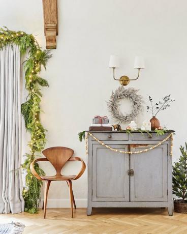 cores de Natal verdes e douradas na vinheta da sala de estar com armário, cadeira e decorações