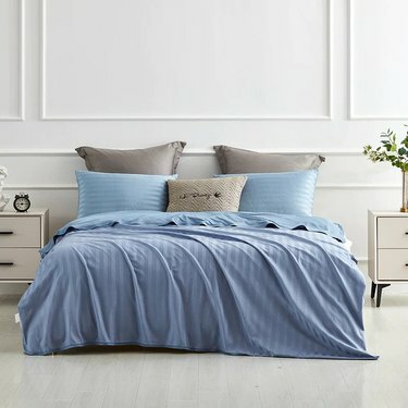Uma cama com um cobertor azul e travesseiros