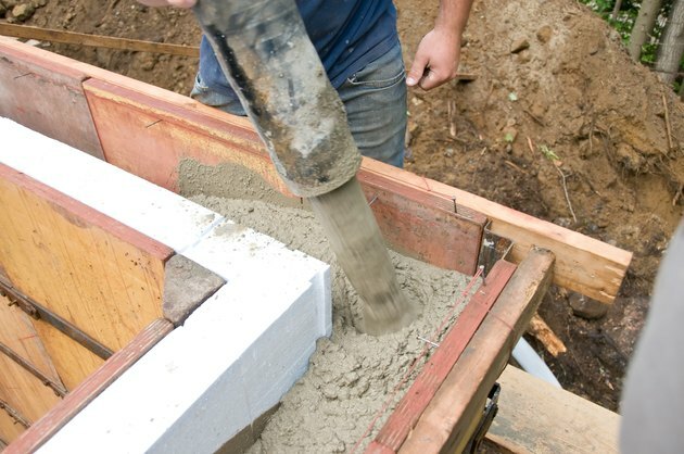 Pracownika budowlanego dolewania beton w ściennej foremce