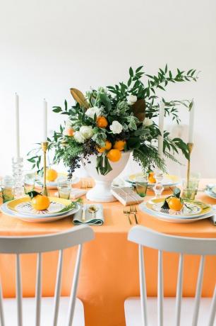 mesa laranja com arranjo de frutas cítricas para decoração de Natal