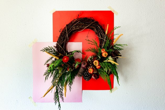 herfstkrans gemaakt met ceder takken, dennenappels, gedroogde bloemen en gedroogde granaatappels