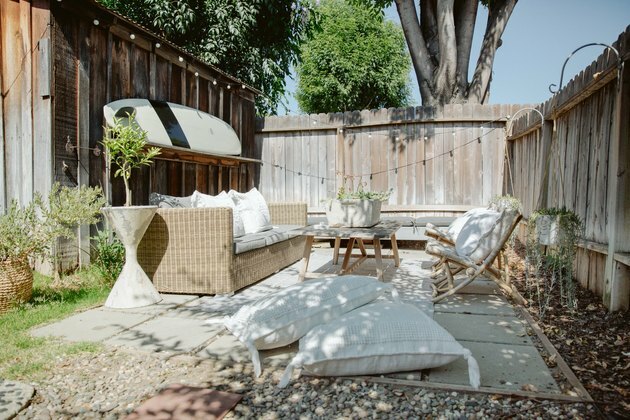 Idea da esterno per il design di un piccolo patio con recinzione, blocchi di cemento, tavola da surf e mobili da giardino naturali